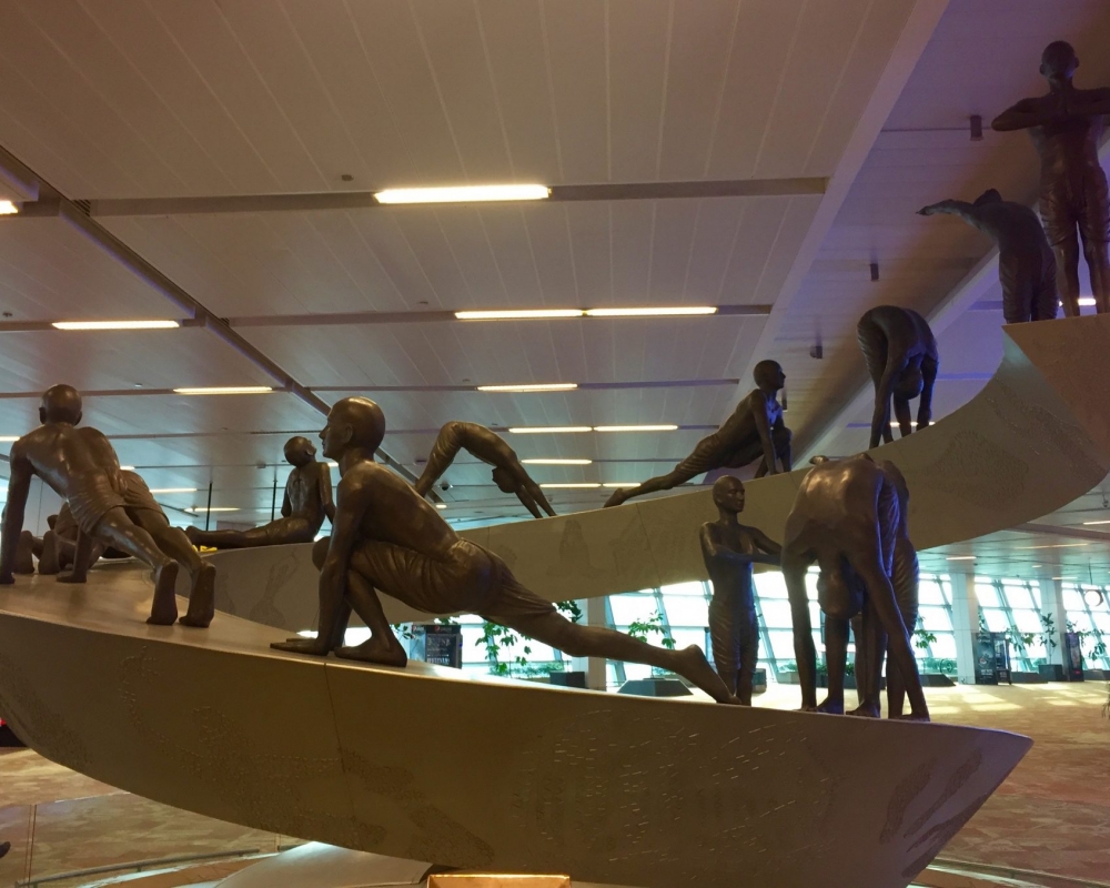 Yogaübung Sonnengruß Delhi Flughafen Yoga-Skulptur Sonnengruß auf dem Flughafen Delhi